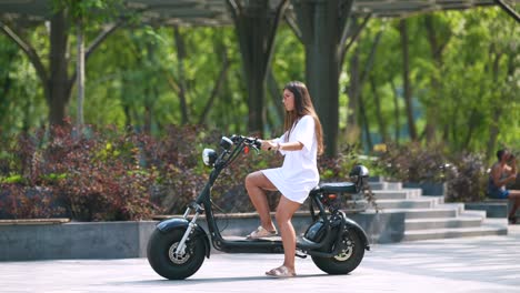 woman riding an electric scooter in a park