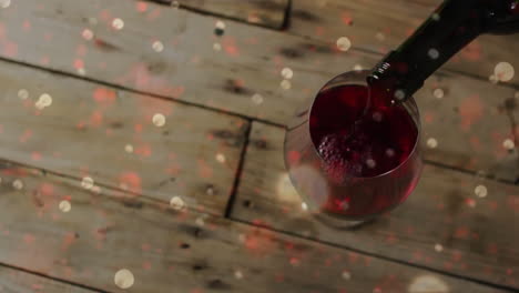 compuesto de vino tinto que se vierte en un vaso sobre un fondo de madera