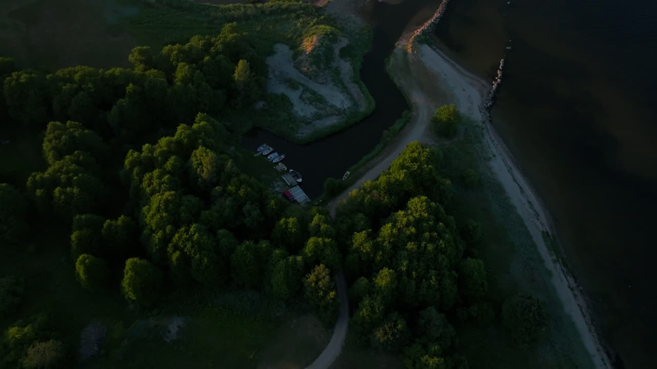 Small boat harbor enveloped by trees during evening light in summertime