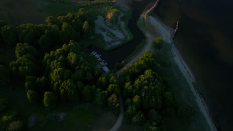 small boat harbor enveloped by trees during evening light in summertime