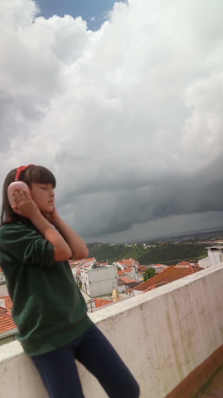 Girl Listening to Music on Rooftop with City View