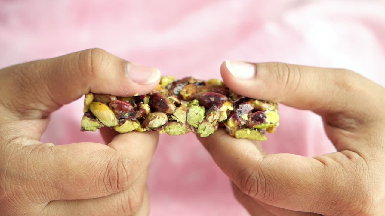 manos sosteniendo un pedazo de caramelo de pistacho