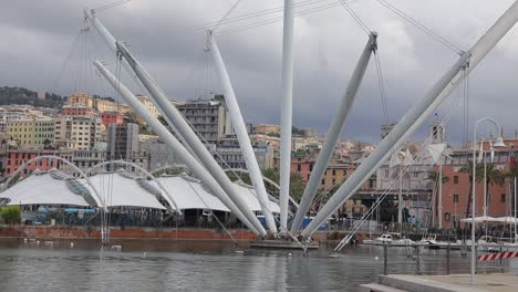 establishing clip over old genoa port, porto antico, in italy showing peaceful waterway and striking architecture