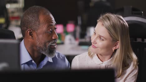 professional businessman and businesswoman discussing while sitting in modern office in slow motion