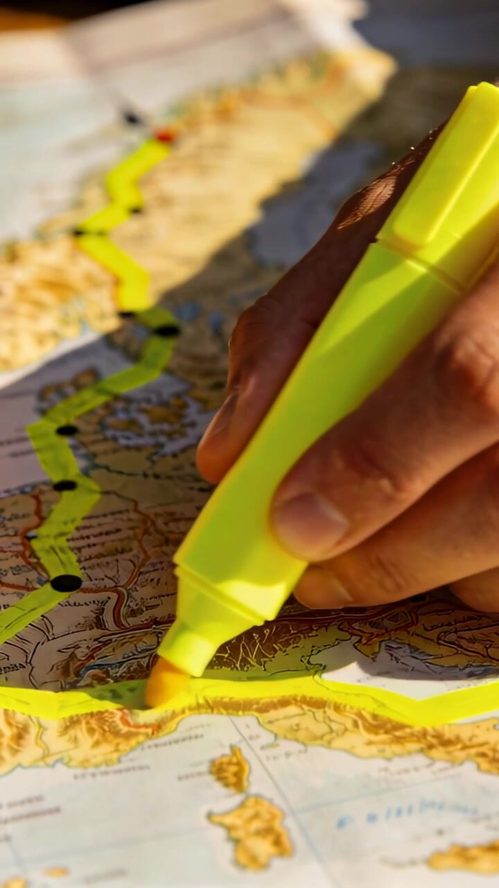 Vertical video: Seeing dots right hand tracing route on map at desk with neon marker, copy space