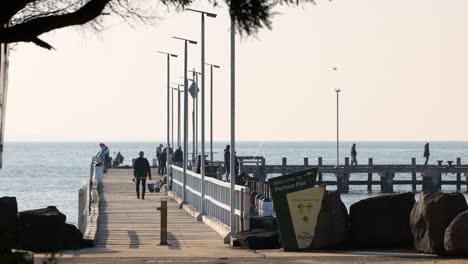 people fishing and walking on a pier