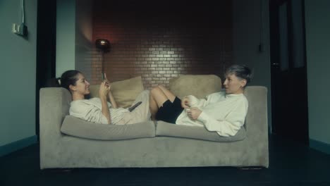 two women relaxing on a couch