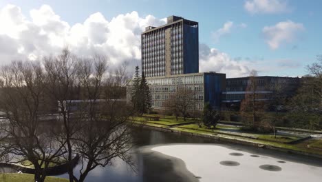 Pilkingtons-Glashauptquartier-Blaues-Hochhaus-Geschäftsbüropark-Antennendolly-Rechter-Blick-über-Den-See