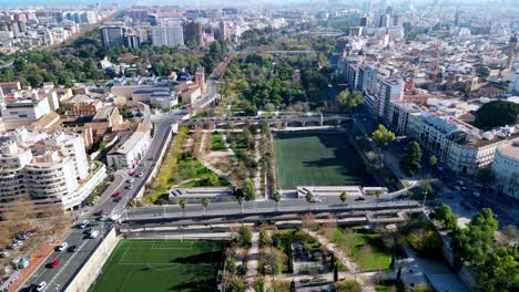 hiperlapso del parque de 9 km de largo ubicado en el centro de valencia en españa, esto muestra las carreteras a ambos lados con edificios y el exuberante parque verde que recorre el centro de la ciudad