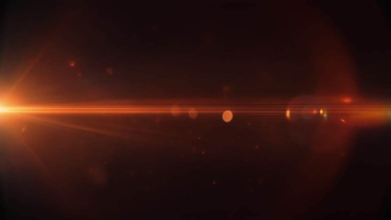 Lens flare arancione brillante con particelle luminose su sfondo scuro
