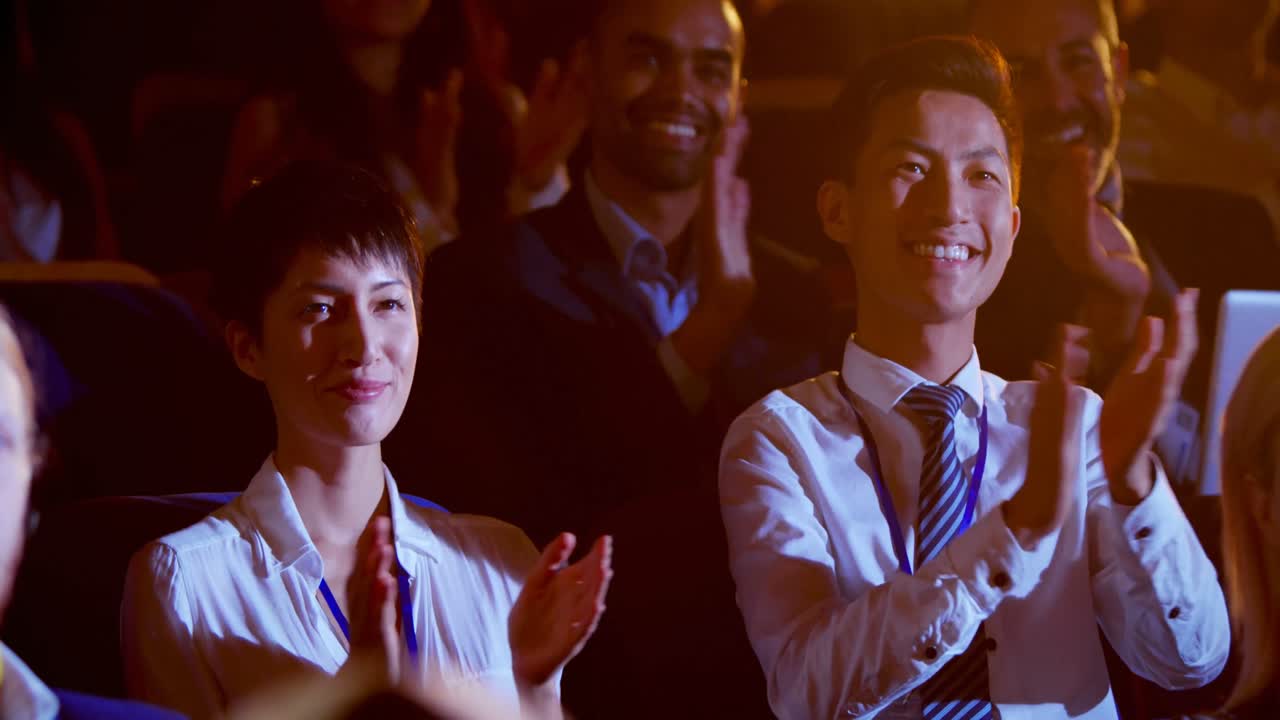 다민족 사업가 들 이 4k 강당 에서 사업 세미나 에서 박수 를 치고 있다