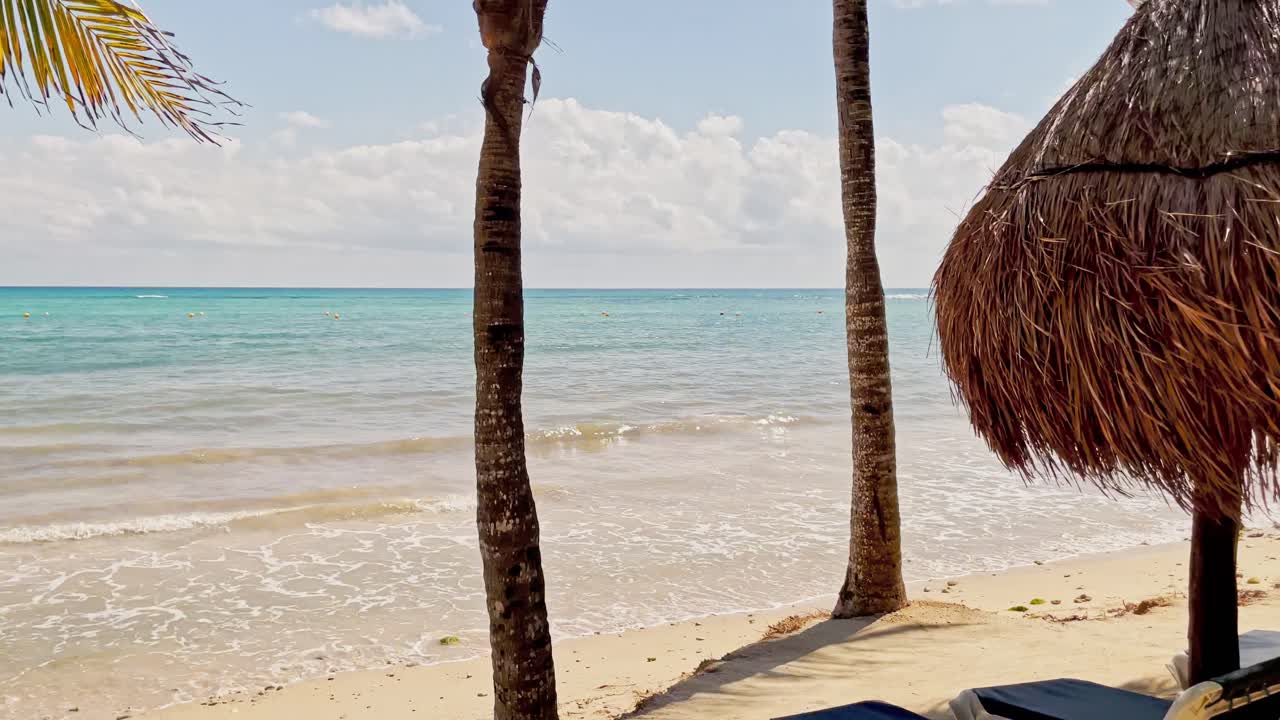 panning toma izquierda del complejo de playa de trs en tulum cancún méxico mostrando la playa y el mar caribe con palmeras y cabañas en primer plano