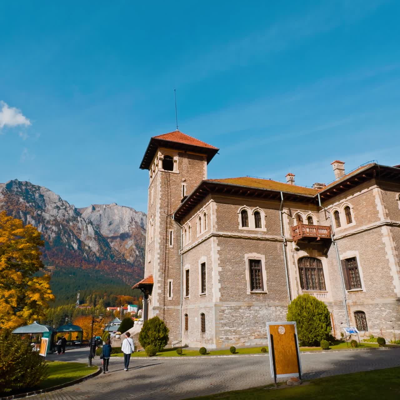 Bellissimo edificio storico e antiquato circondato da alberi autunnali. Splendide montagne sullo sfondo