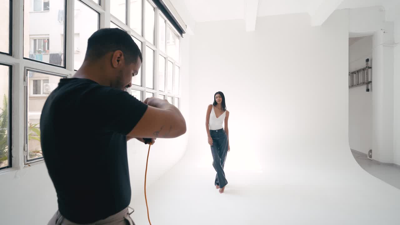 Fashion photoshoot behind the scenes with a model and photographer in a studio