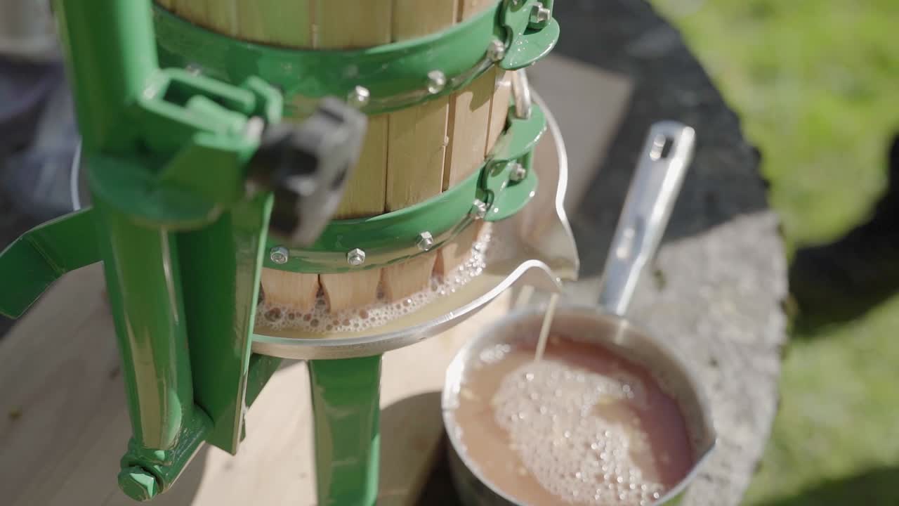 jugo de manzana que sale de una prensa de jugo de manzana