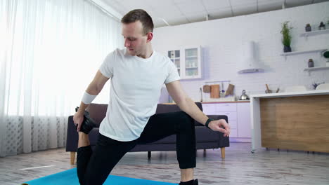 strong athletic active person working out indoor. handsome healthy man training his body in home.