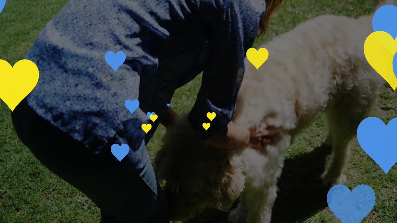 animación de corazones sobre mujer caucásica acaricia perro