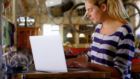 Woman-using-laptop-at-workshop-4k-