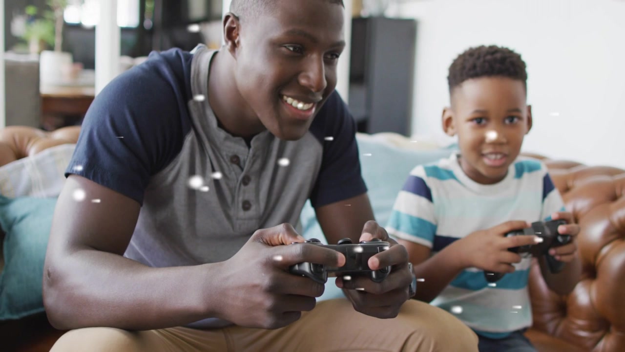 Dad and son on sofa, holding pads, white particles orbiting hands, fist bumping after gaming win