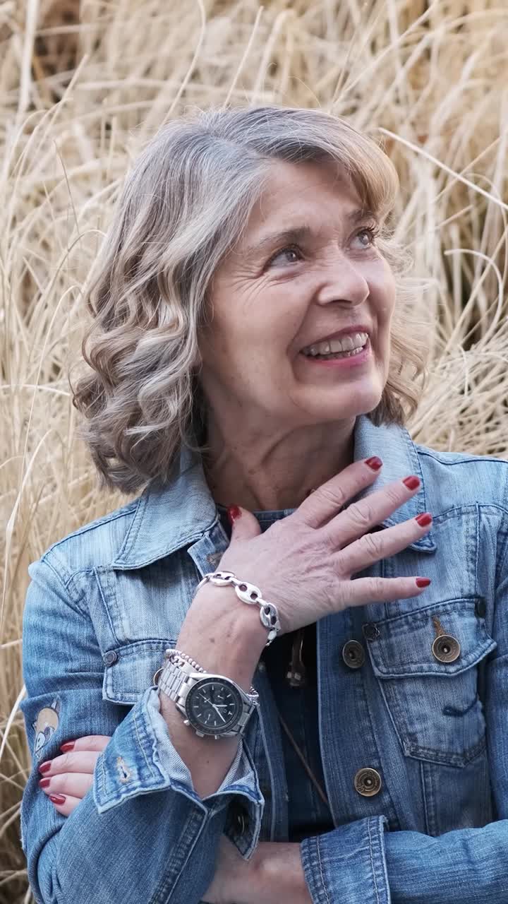 Cheerful women talking to crop friends against dry grass. Vertical footage