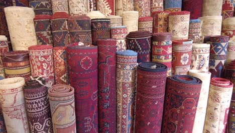 rolled up rugs on display in a market