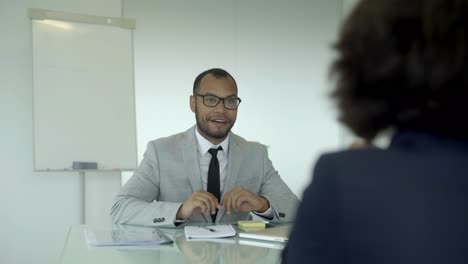 cheerful young man sitting at table and talking