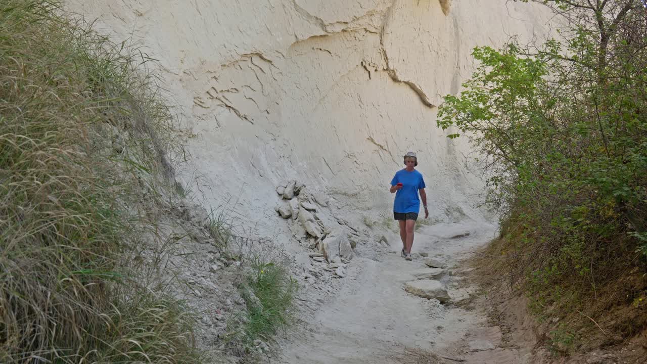 Woman strolls rocky nature trail enjoys solitude contemplation therapy
