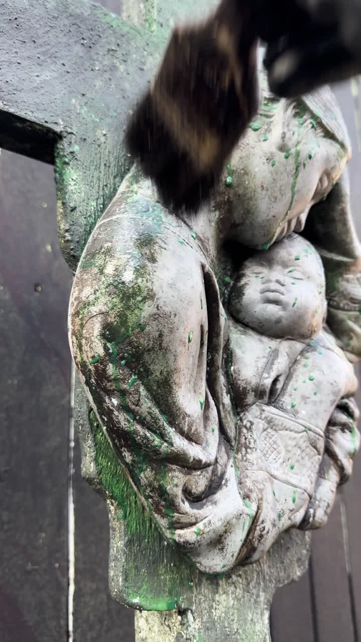 Konstnär som åldrar en stenstaty med pensel, närbild