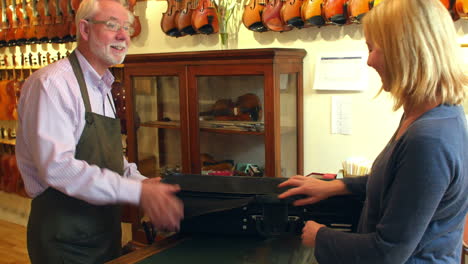 customer collecting violin from shop after repair