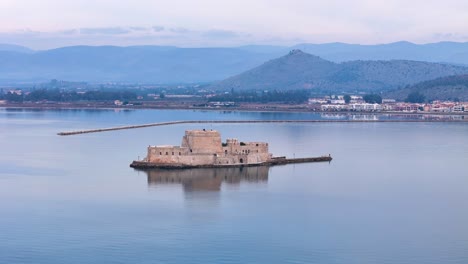 Impresionante-Perspectiva-Aérea:-Castillo-Acuático-De-Bourtzi-En-La-Pintoresca-Región-Del-Peloponeso,-Grecia