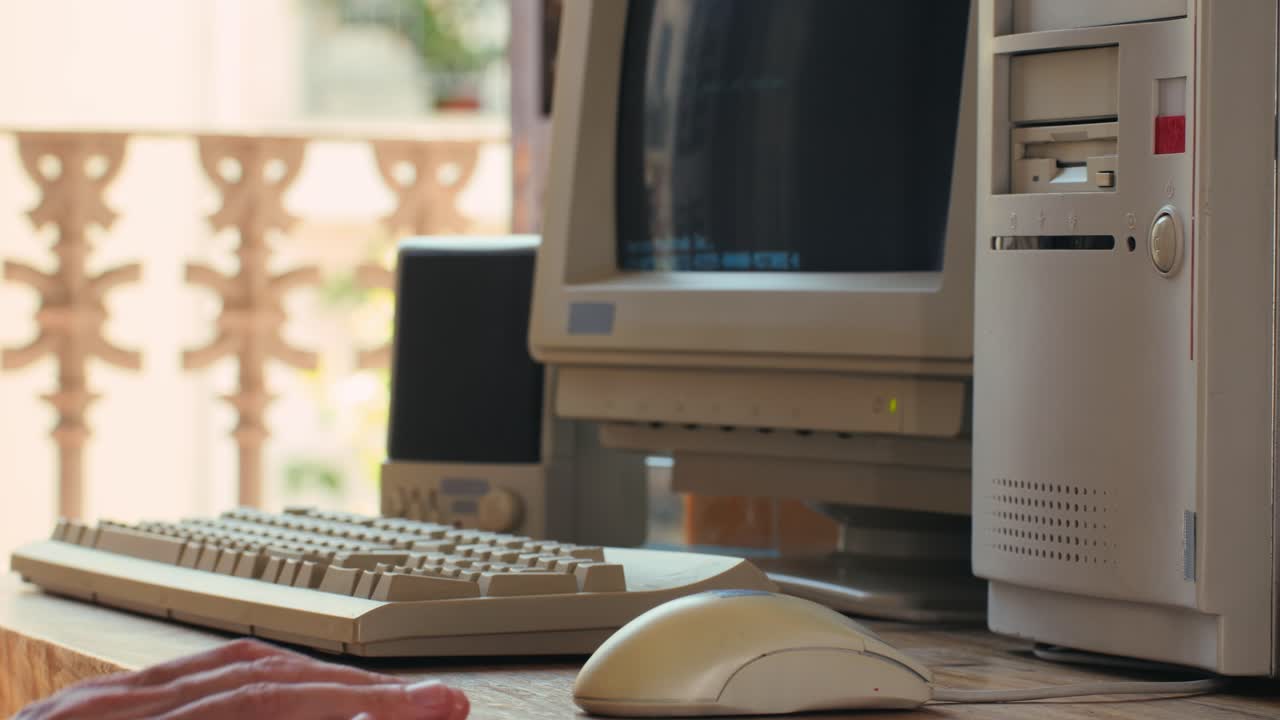 Man working and gaming on retro computer PC, IT engineer with vintage computer at home, using old fashion technology, close up of retro setup.