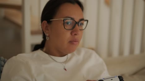 a beautiful pregnant woman sitting comfortably at home, enjoying video games on a tv console. the scene blends relaxation, modern entertainment, and maternity in a cozy setting