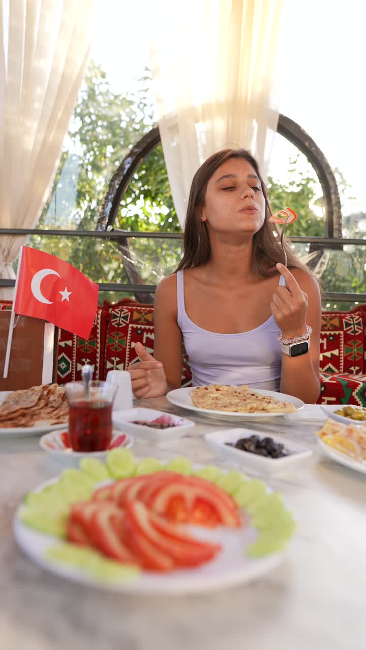 una mujer joven disfrutando de un desayuno turco.