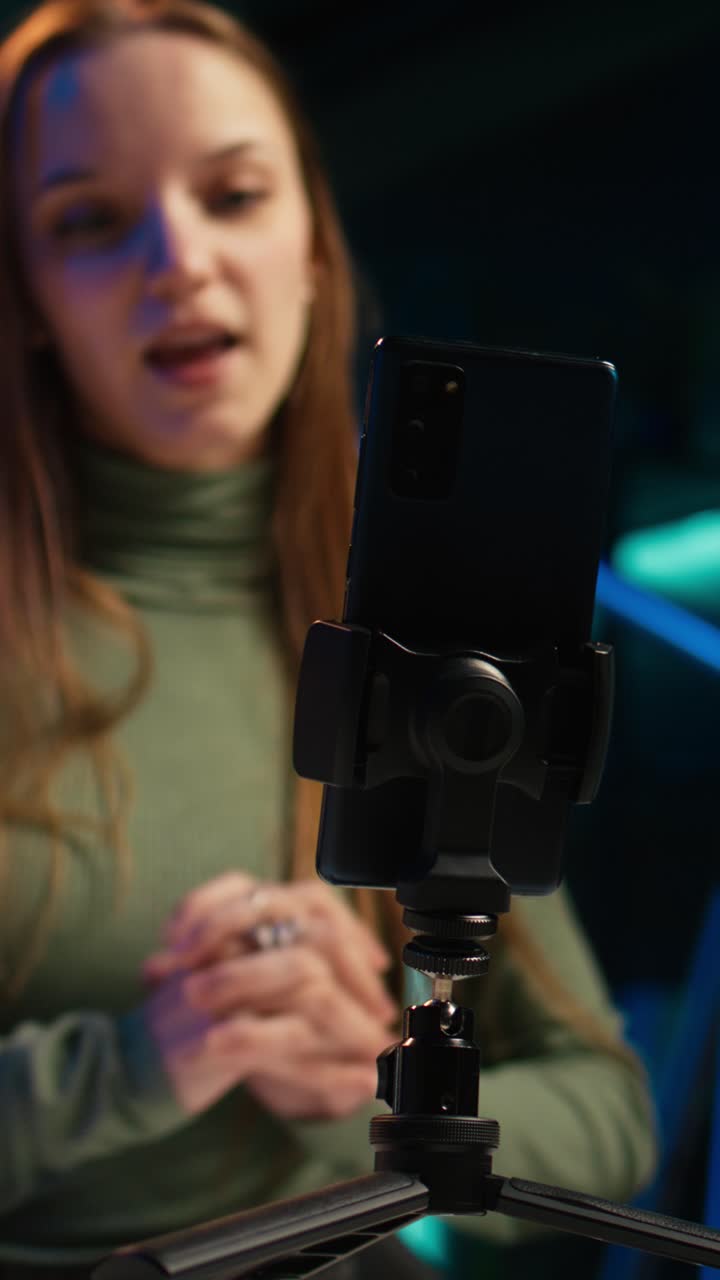 Giovane donna che parla allo smartphone su un treppiede per una videochiamata