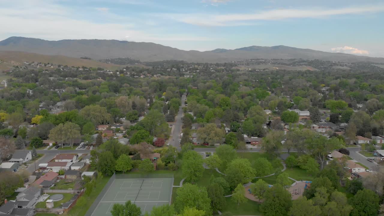 toma aérea de paso elevado del vecindario con drones con vista a las montañas rocosas y puesta de sol