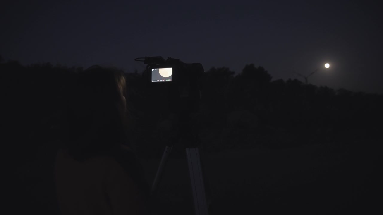 Donna che filma la luna piena
