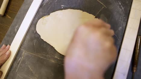 woman shaping clay with tools