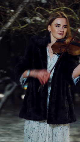 street musician playing on violin. musician girl singing melody on his violin. vertical video