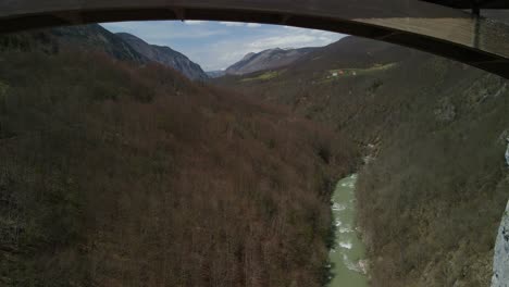 drone footage flying under durdevica tara bridge toward the mountains in montenegro