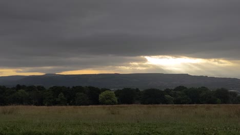 Wunderschöner-Sonnenaufgang-Im-Zeitraffer-Mit-Lichtstrahlen,-Die-Auf-Den-Hügel-Scheinen