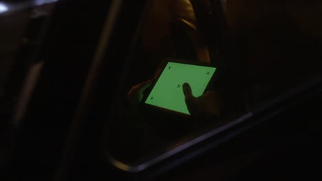 person using tablet in a car at night