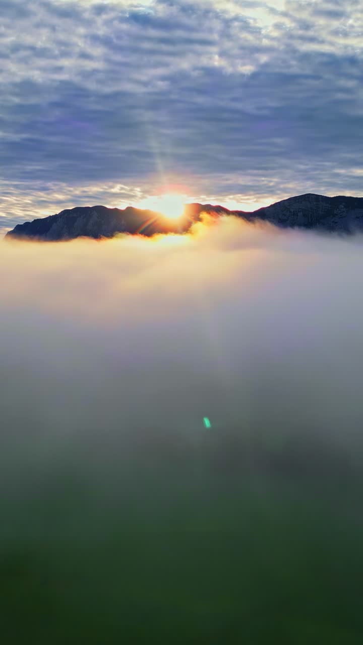 Vertical View Of Sea Of Clouds With Mountain Peaks At Sunset. Aerial Shot