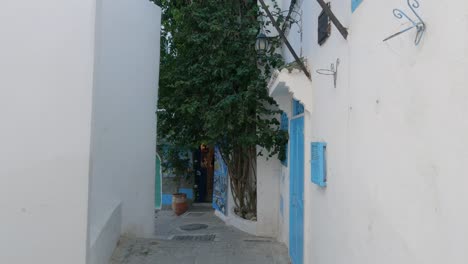 pan down view along narrow quaint street in tangier of building with bright blue door and window frame