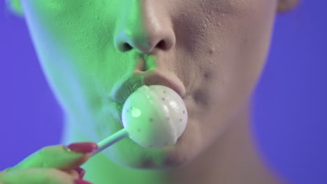 mujer lamendo helado con seducción, boca en primer plano en fondo púrpura