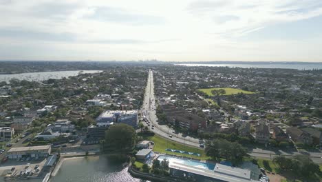 Aerial-forward-flying-toward-the-dual-carriageway-highway-between-properties