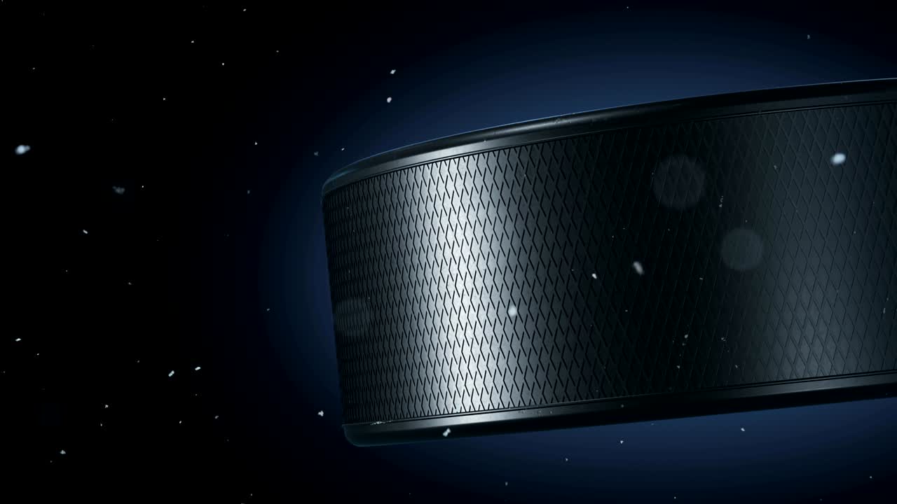 hermoso disco de hockey girando en primer plano con copos de nieve volando alrededor en cámara lenta sobre fondo negro. hockey en bucle animación 3d de girar el disco aislado.