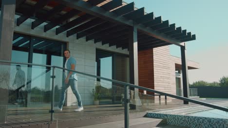 happy man inviting enter home. handsome man waving hand to come in luxury house