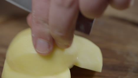 Close-up-of-chef-cutting-raw-potatoes-into-slices