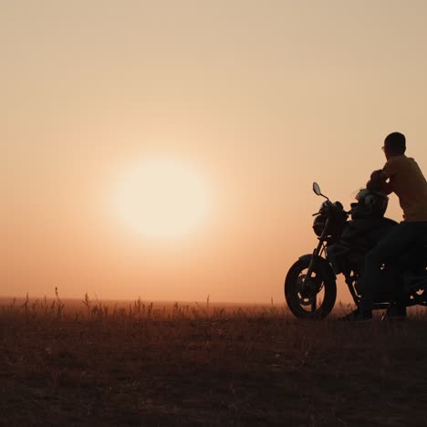 Junger-Mann-Sitzt-Auf-Einem-Motorrad-Und-Bewundert-Den-Sonnenuntergang-1