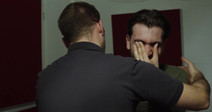 Due uomini in una situazione emotiva, con una persona che conforta e supporta un'altra che appare angosciata o sopraffatta. Concetto di empatia, amicizia, salute mentale, supporto emotivo, compassione.